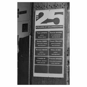 Panneau Le 25 sur la porte d'entrée indiquant les noms des ateliers et galeries d'art.